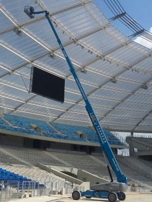 Кран на майданчику стадіону встановлює освітлення.